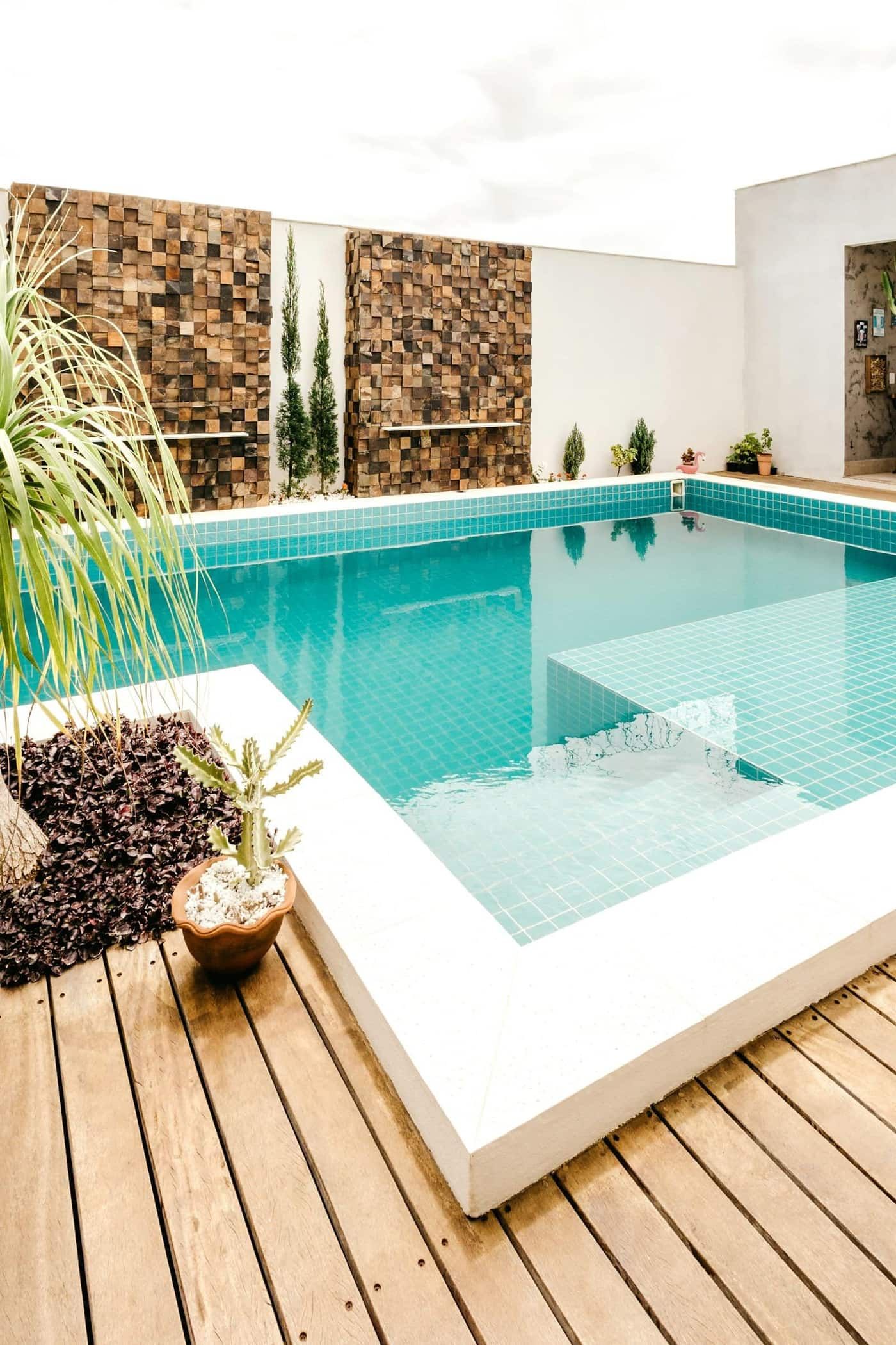 After: Backyard transformed from bare concrete slab to travertine pool deck with outdoor kitchen