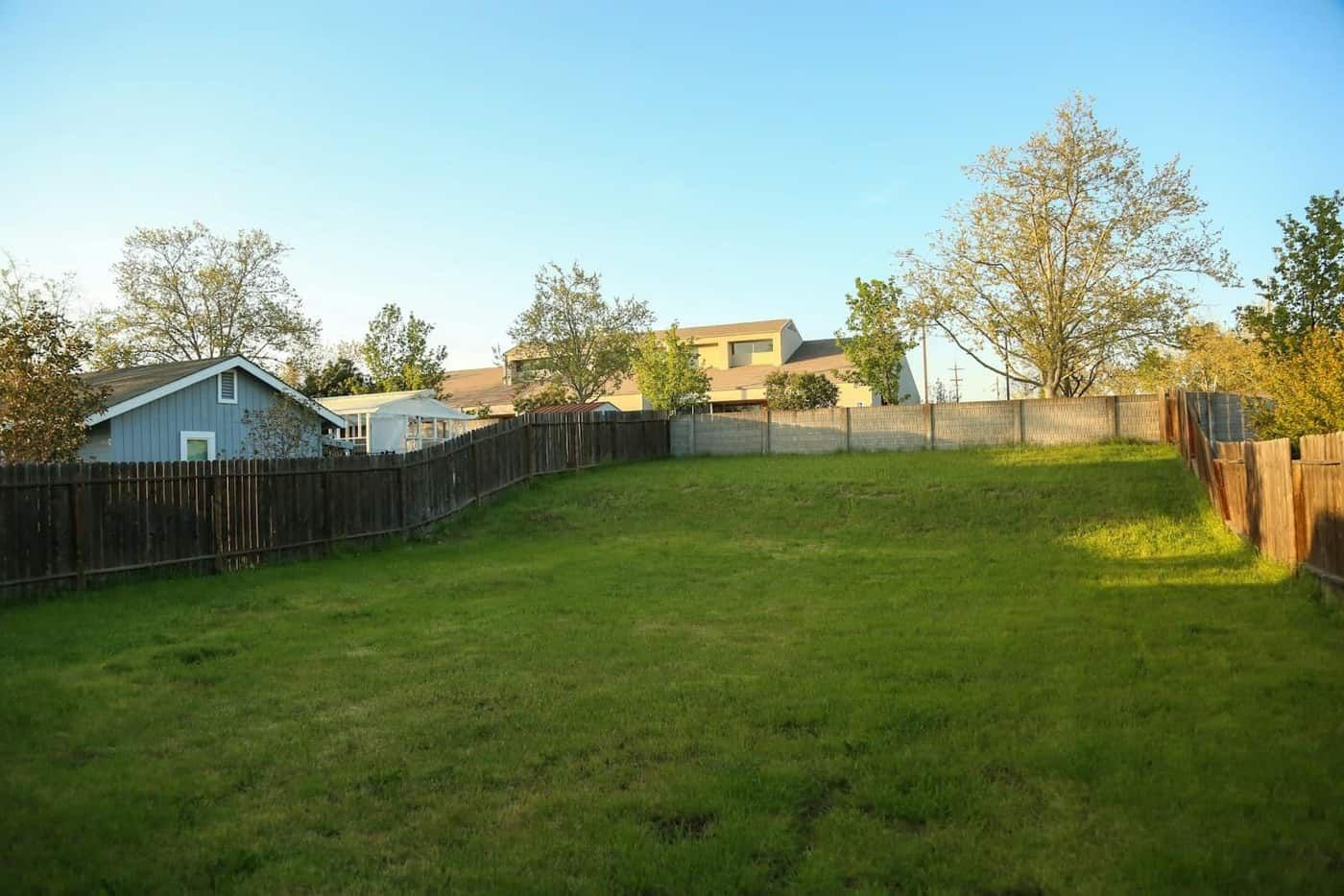 Before: Backyard transformed from bare concrete slab to travertine pool deck with outdoor kitchen